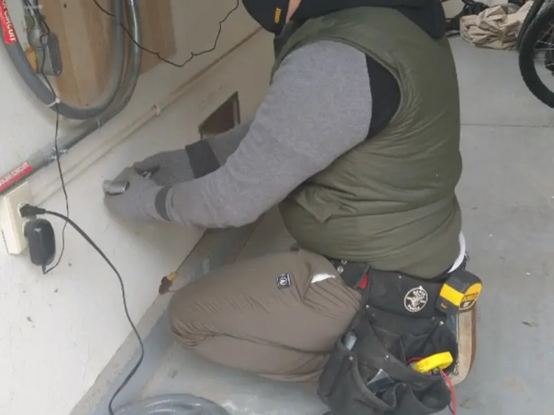 Electrician performing outlet wiring in a Franklin Park garage